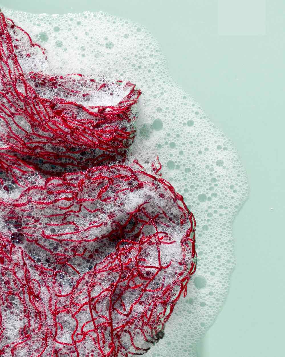 Fischnetz with benefits as a kitchen sponge alternative. The net is wet and has foam on it.