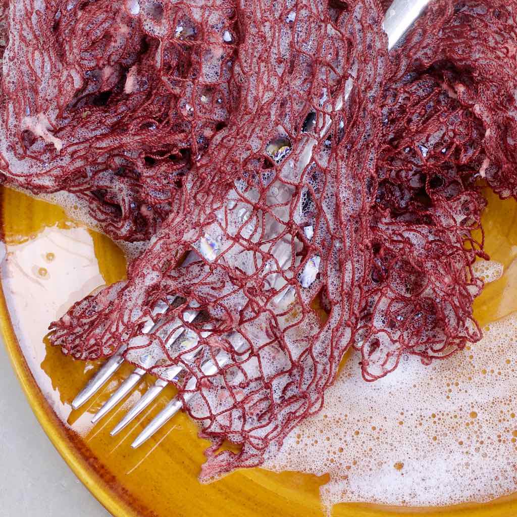 Zoom on foamy Fischnetz with Benefits cleaning a fork.