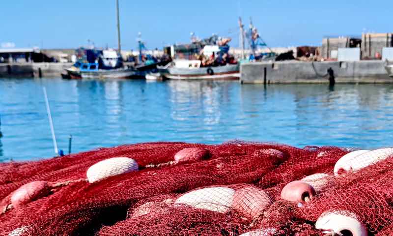 Gebrauchte rote Fischernetze als Schwamm Alternative. Die netze liegen in einem marokkanischen Hafen.