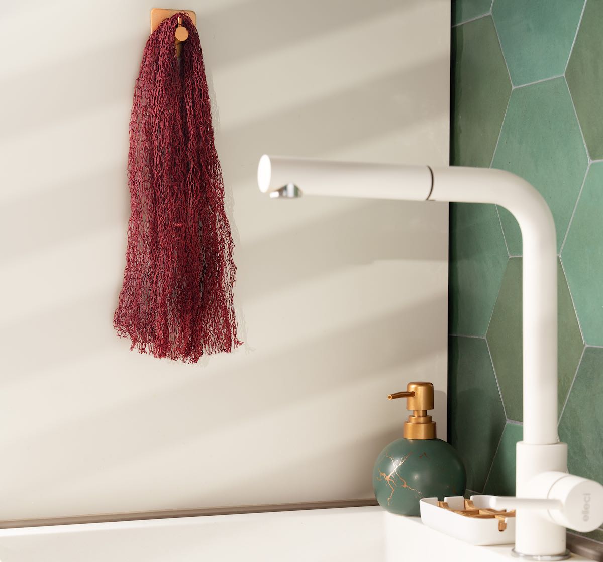 Red dry Fischnetz With Benefits hangs in kitchen next to a sink.